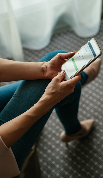 A woman uses her mobile device to check out from her hotel room and get an email receipt.